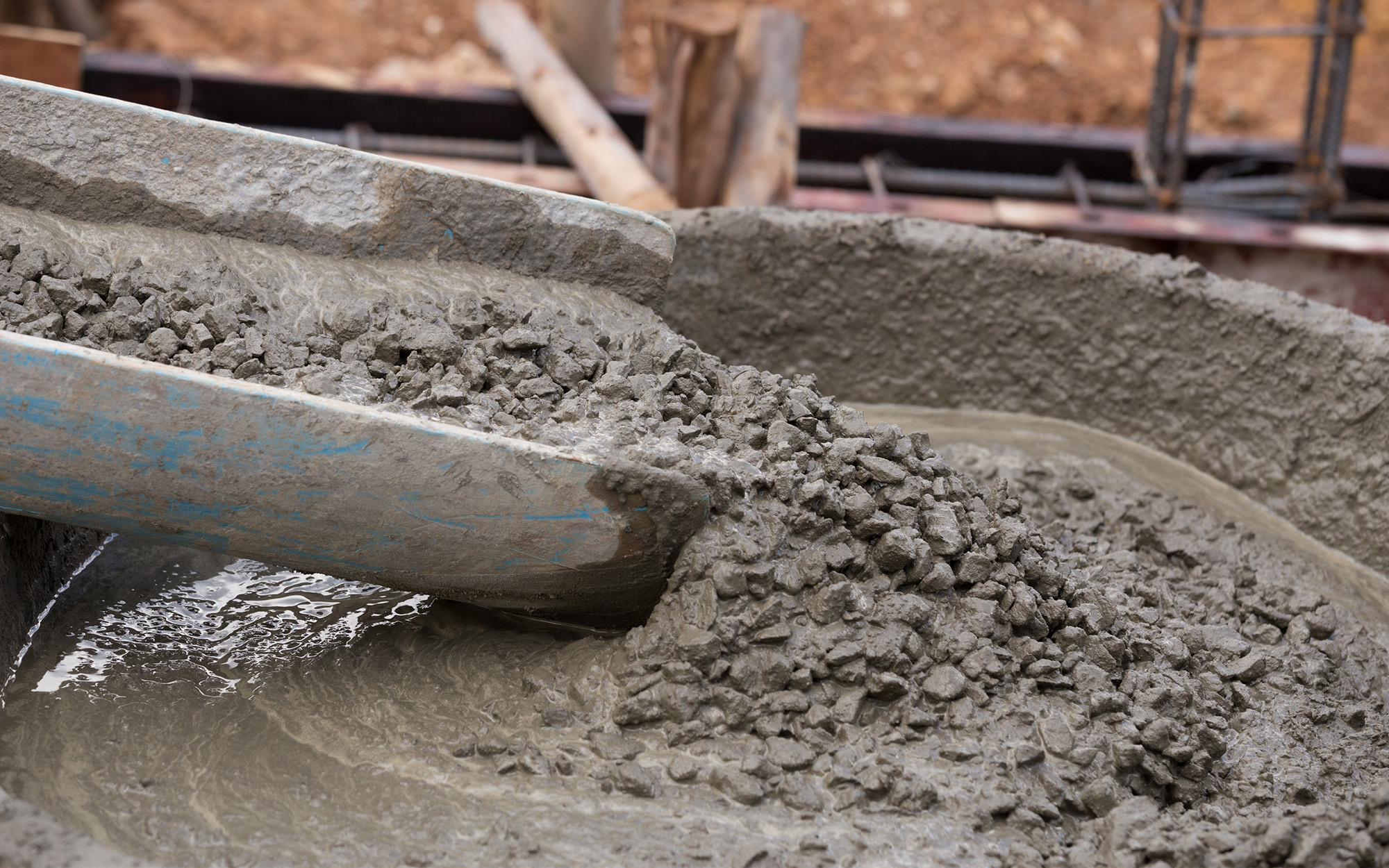 Side view, mixed concrete pouring at construction site